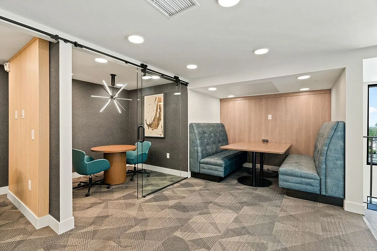 Coworking space area with cozy blue booth seating and elegant round meeting space, ideal for collaboration and relaxation at The Richmond Apartments in SLC Utah