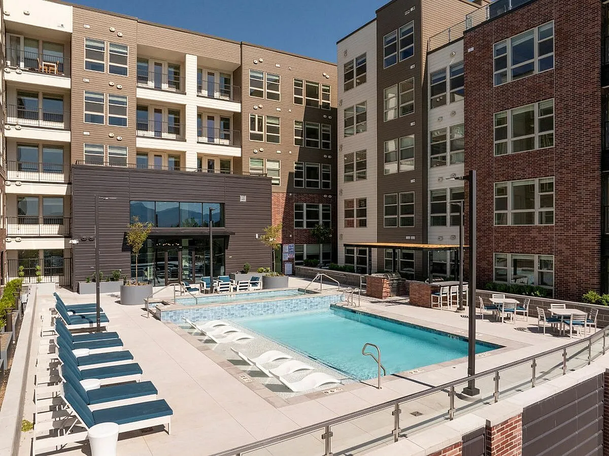 Pool deck with spacious patio and inviting pool, surrounded by stylish multi-story buildings at The Richmond Apartments in Salt Lake City Utah