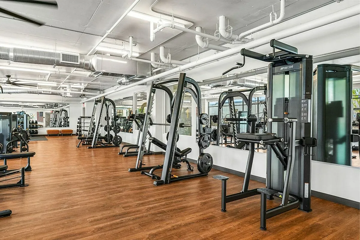 Spacious and modern fitness center with state-of-the-art gym equipment, mirrored walls, and sleek wooden flooring in Salt Lake City Utah
