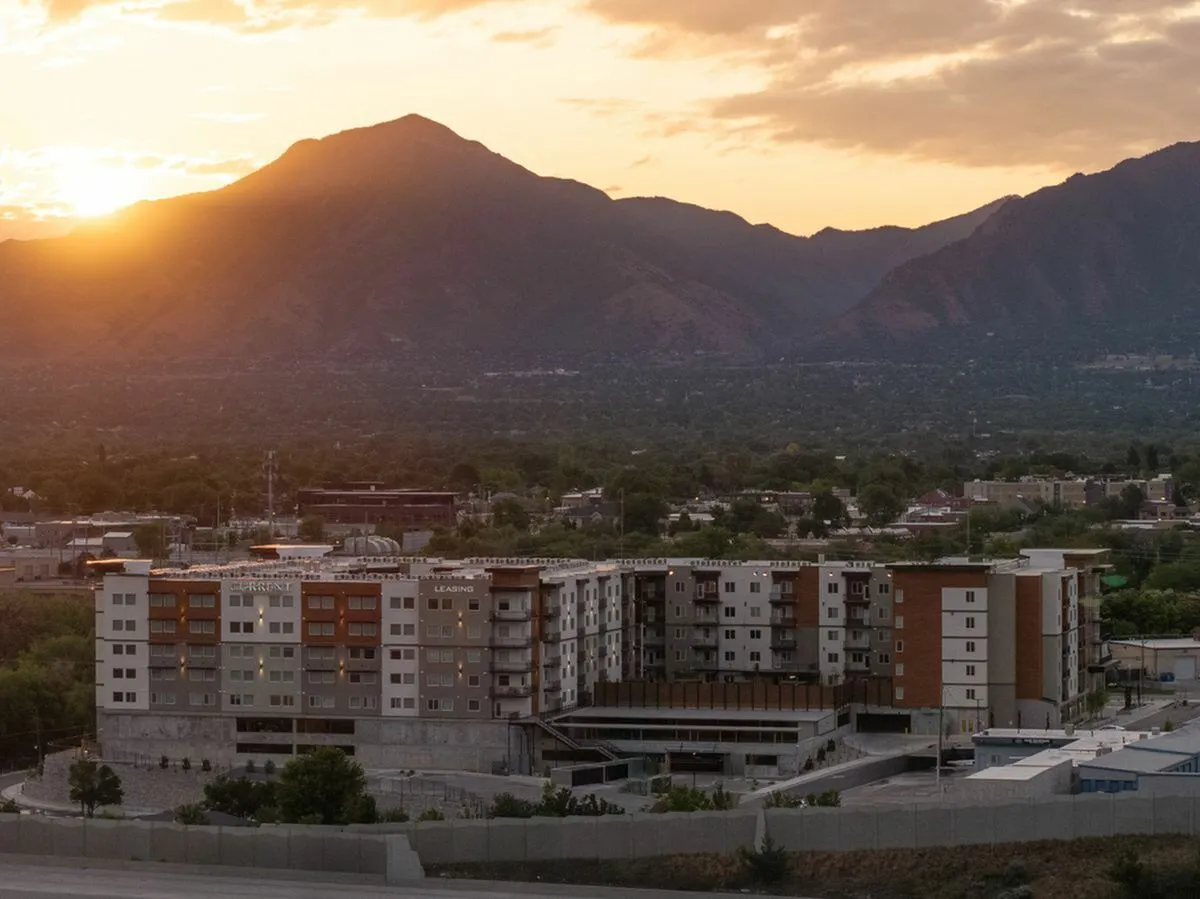 Stunning apartment complex with panoramic mountain views at sunset, offering serene living in a vibrant community at Current Apartments in Murray Utah