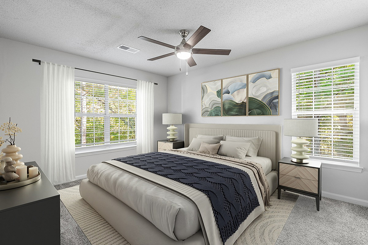 Bright, modern bedroom at Retreat at Peachtree City Apartments with large windows, elegant decor, and plush bedding in a serene setting.