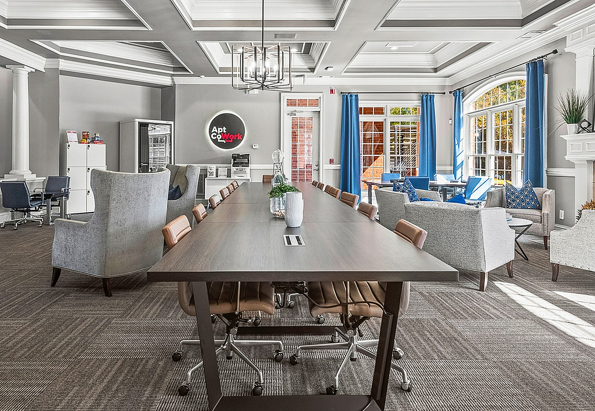 Elegant co-working space at Retreat at Peachtree City Apartments with a long conference table, stylish seating, and large windows letting in natural light, perfect for productivity and collaboration.