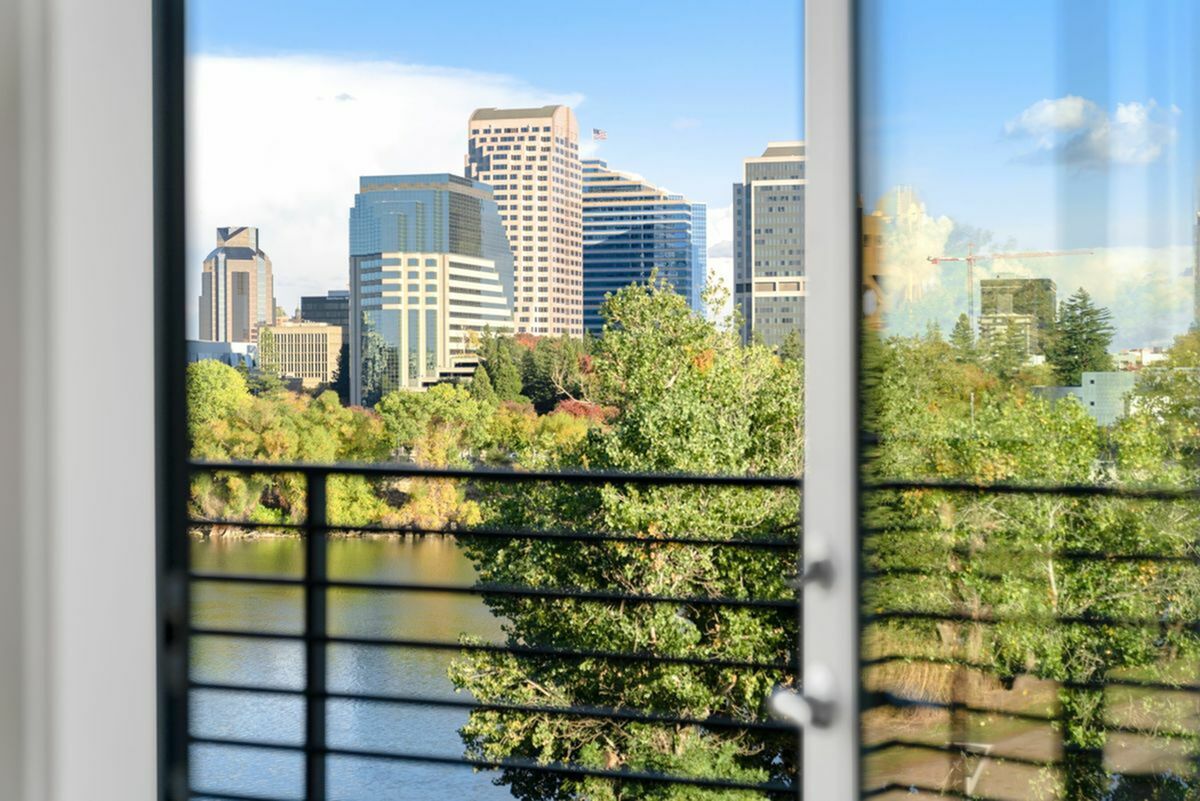 Breathtaking urban view of city skyline from a modern apartment, showcasing a vibrant city skyline and lush greenery by the river at 805 Riverfront Apartments in West Sacramento