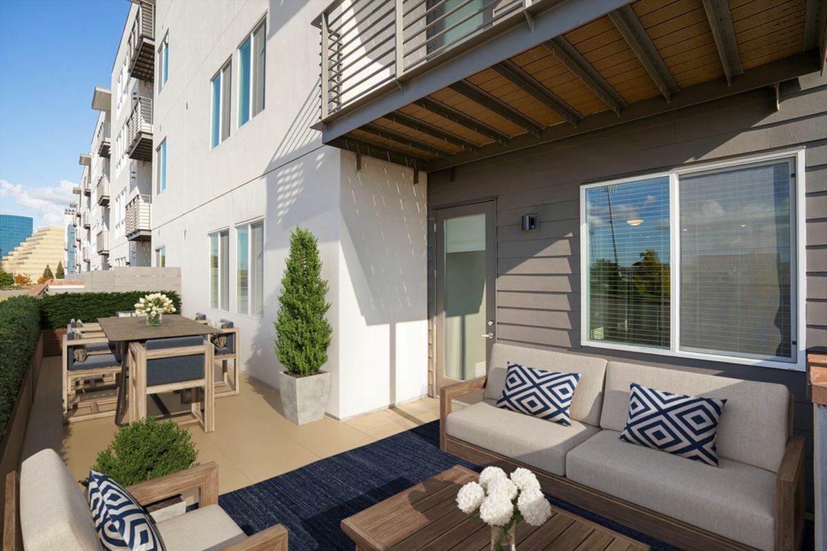 Chic apartment balcony with cozy seating area, stylish cushions, and a modern dining set, perfect for outdoor relaxation at 805 Riverfront is West Sacramento