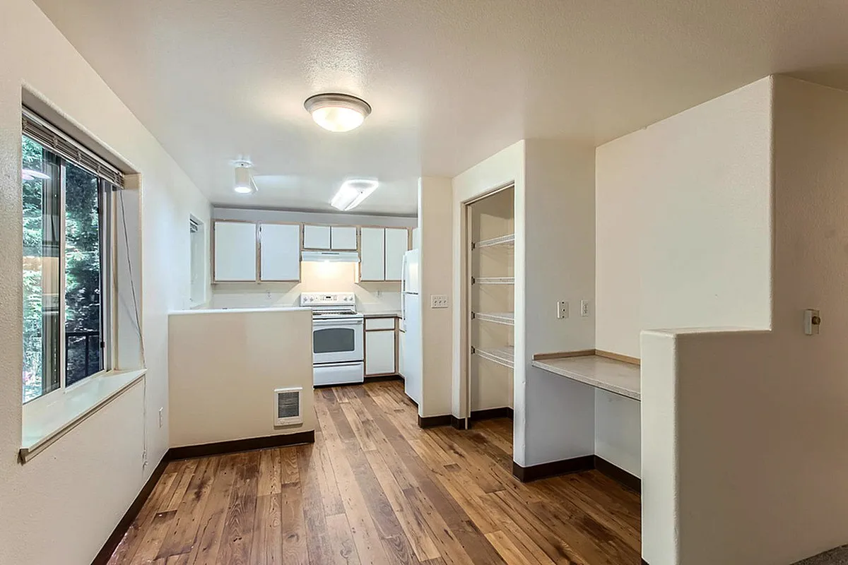 Bright, open kitchen at Scott Mountain Apartments with modern cabinetry and hardwood flooring.