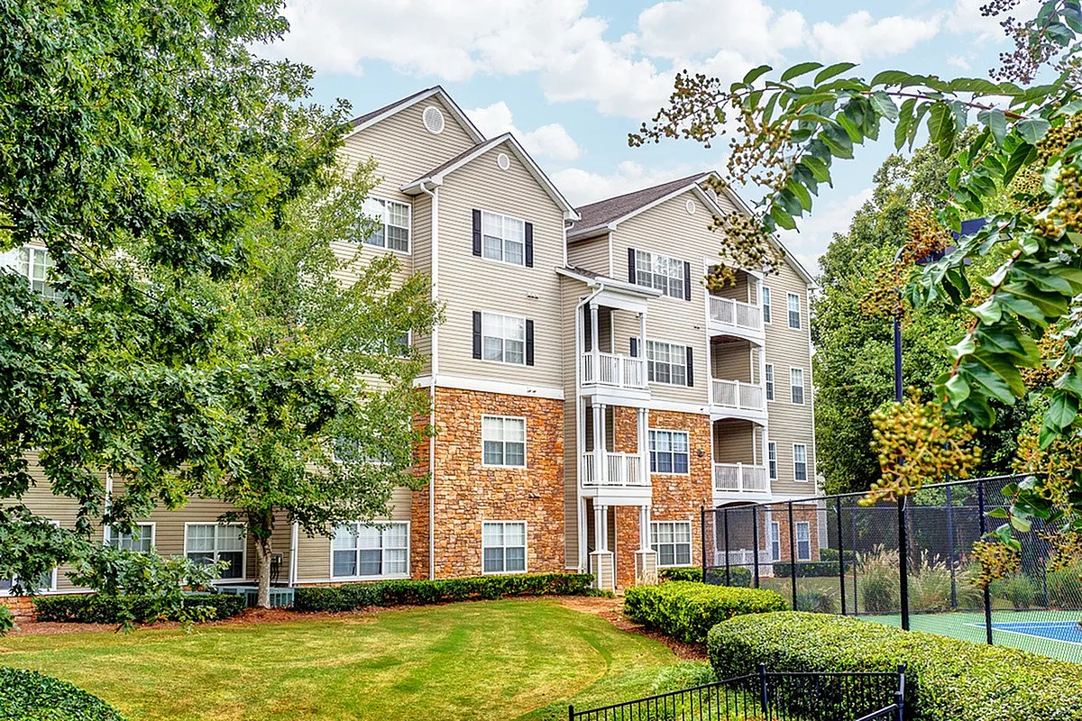 Inviting residential building with charming balconies, surrounded by lush greenery and vibrant landscapes, offering a serene living environment at Summer Park Apartments.