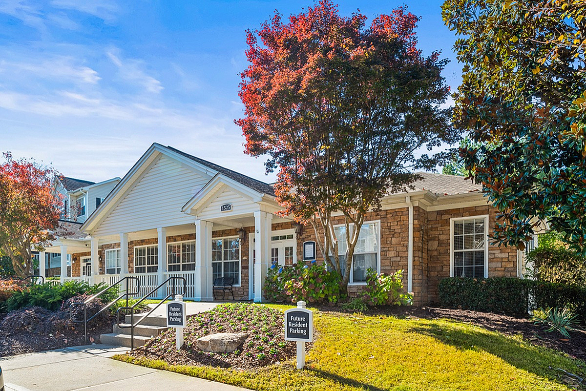 Inviting community clubhouse at Summer Park Apartments with charming brick exterior and lush landscaping, perfect for future residents.