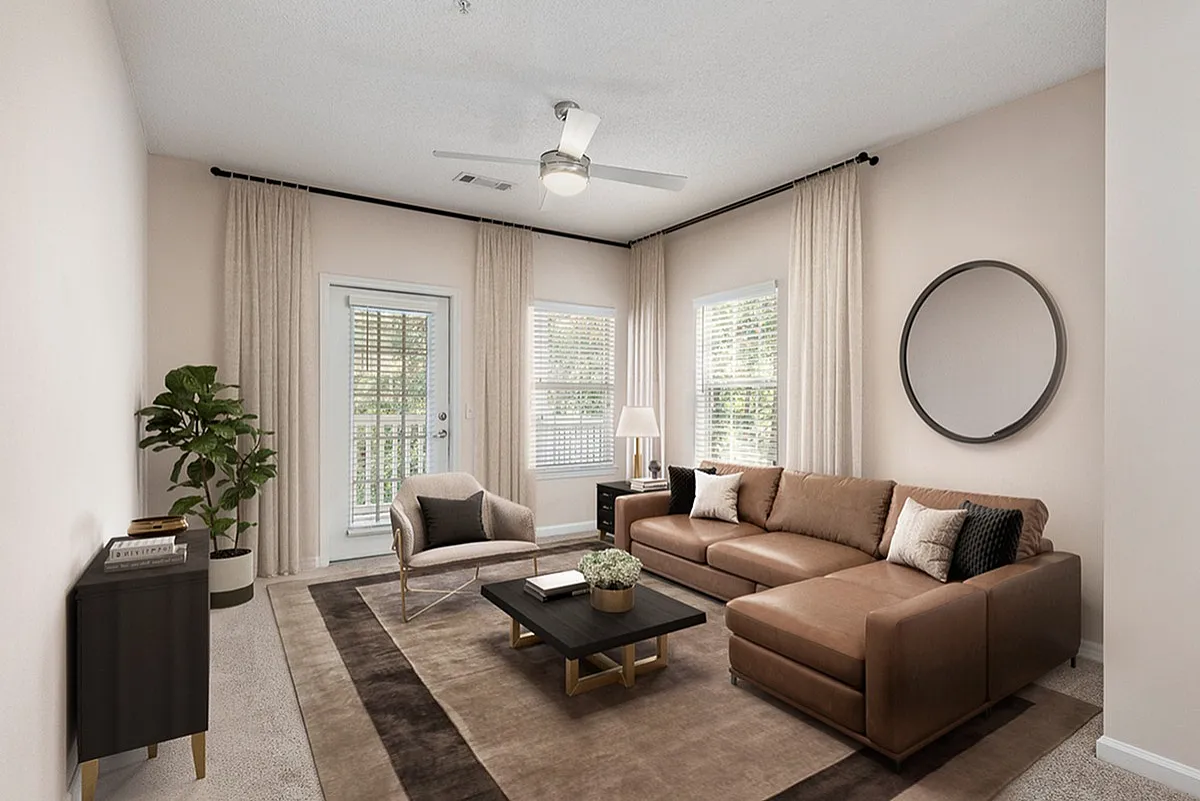 Elegant living room at Summer Park Apartments featuring a cozy brown sectional, plush area rug, and a stylish coffee table, with natural light streaming through large windows.