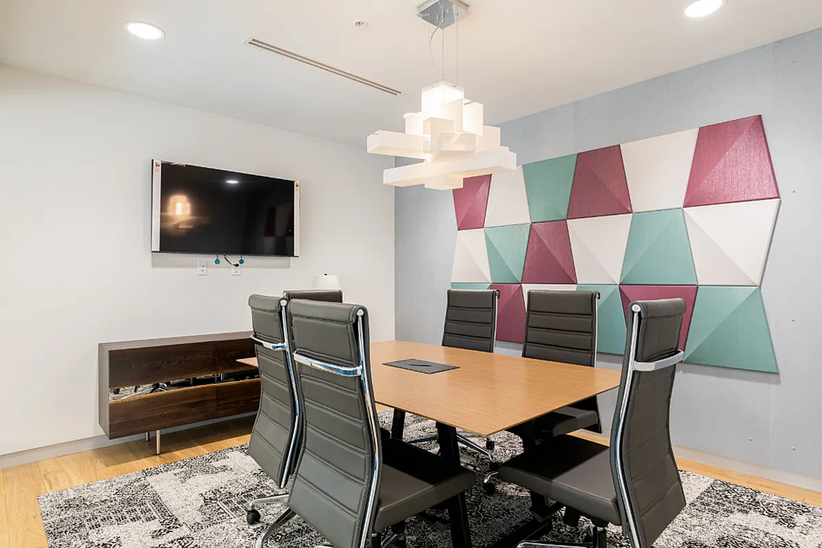 Modern conference room featuring a sleek wooden table, executive leather chairs, geometric wall art, and ambient lighting perfect for productive meetings  at Apt CoWork at Sugarmont Apartments in SLC