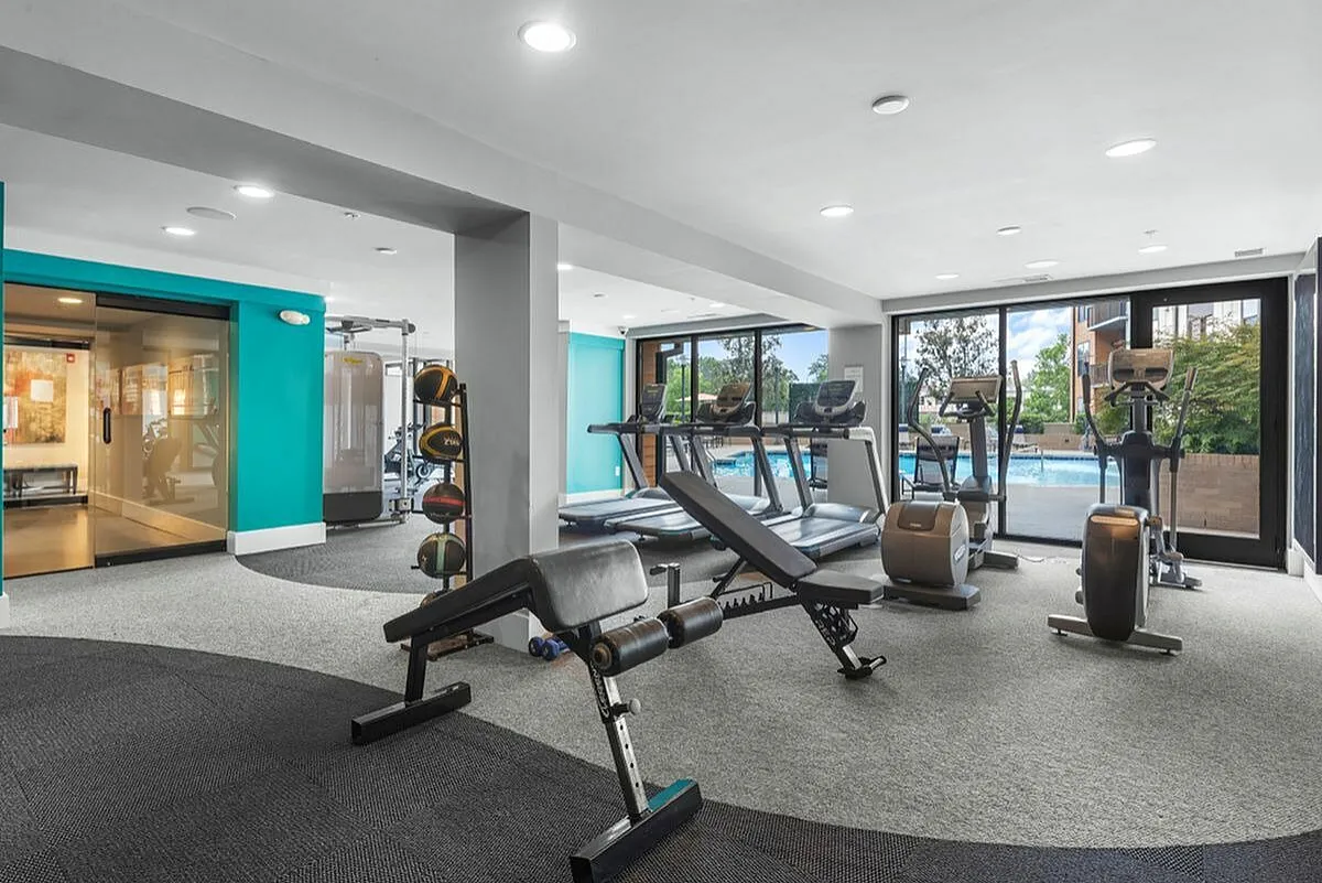 Modern fitness center with state-of-the-art equipment, panoramic windows, and pool view at Cottonwood Westside Apartments in Midtown Atlanta
