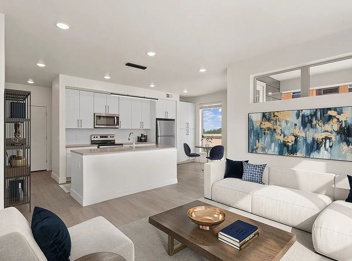 Contemporary open-concept living space with a sleek kitchen, elegant seating area, and vibrant artwork, perfect for modern living at The Richmond Apartments in Millcreek, Utah.