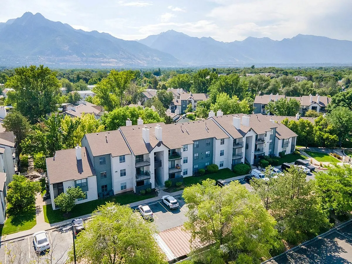 Charming apartment complex nestled in lush greenery with stunning mountain views, highlighting scenic and inviting living spaces at Cottonwood Apartments in SLC
