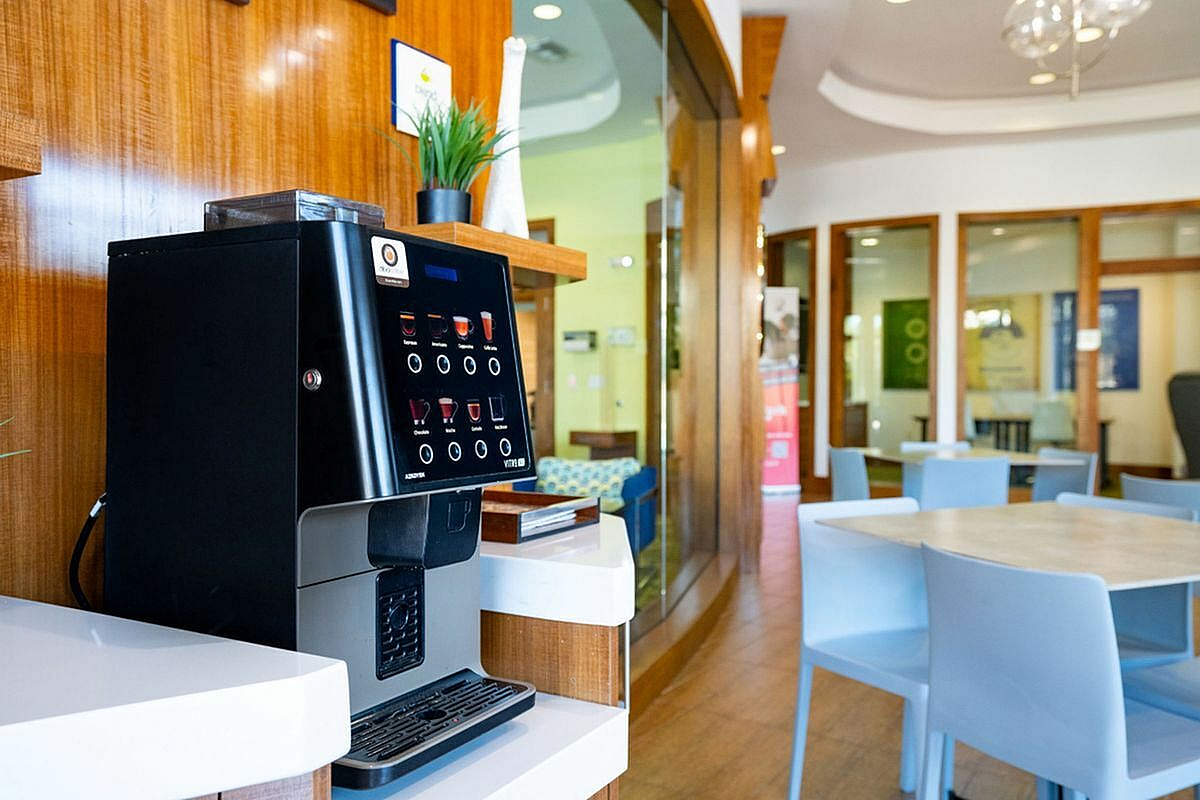Free coffee and modern seating, perfect for relaxation and socializing at Apt CoWork at The Marq Highland Park in Tampa