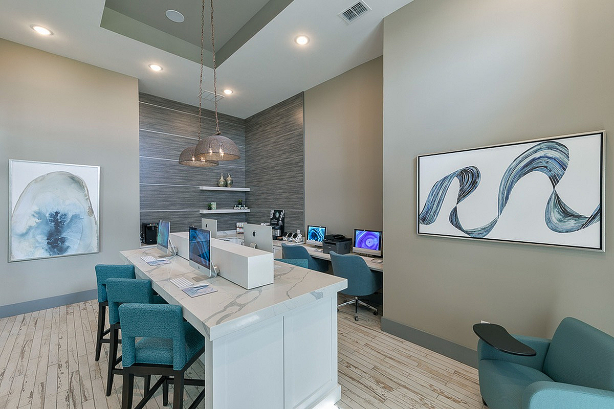 Modern co-working space at Cottonwood Clermont in Clermont, FL featuring sleek computers, elegant lighting, and stylish artwork on the walls.