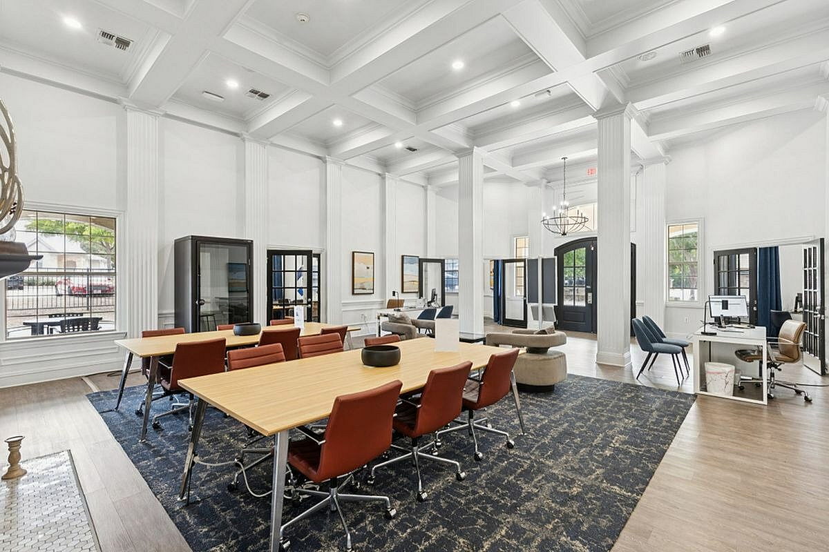 Luxurious office space with high ceilings, elegant chandeliers, and spacious seating areas designed for productivity and comfort at Apt CoWork at Stonebriar at Frisco Apartments