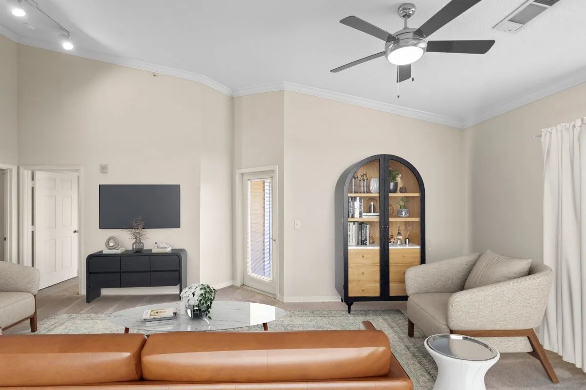 Elegant living room with modern decor, featuring a stylish ceiling fan, comfortable seating, and a chic TV stand at Cottonwood Reserve Apartments in Charlotte