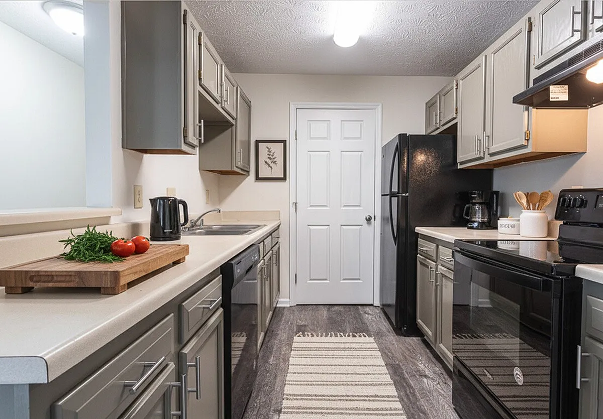 Charming modern kitchen with sleek cabinetry, elegant countertops, and stainless steel appliances, perfect for culinary enthusiasts at Crown Pointe Apartments.