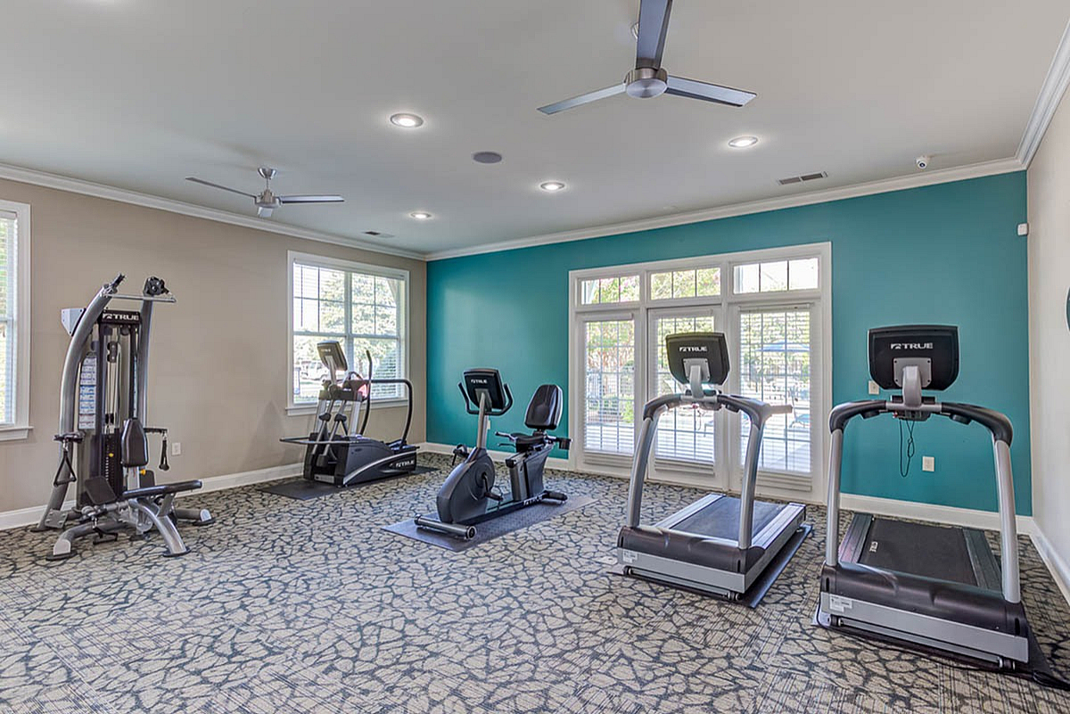 Modern gym at The Stratford at Hillcrest Towne Center Apartments equipped with state-of-the-art exercise machines, large windows providing abundant natural light, and stylish interiors.