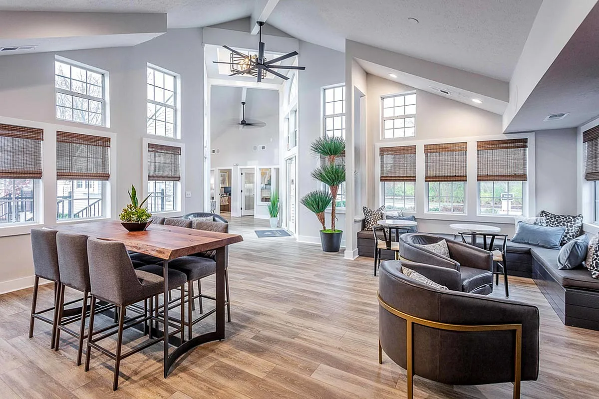 Bright and inviting resident clubroom at The Retreat at Stillmeadow Apartments featuring modern furnishings, large windows, and chic decor.