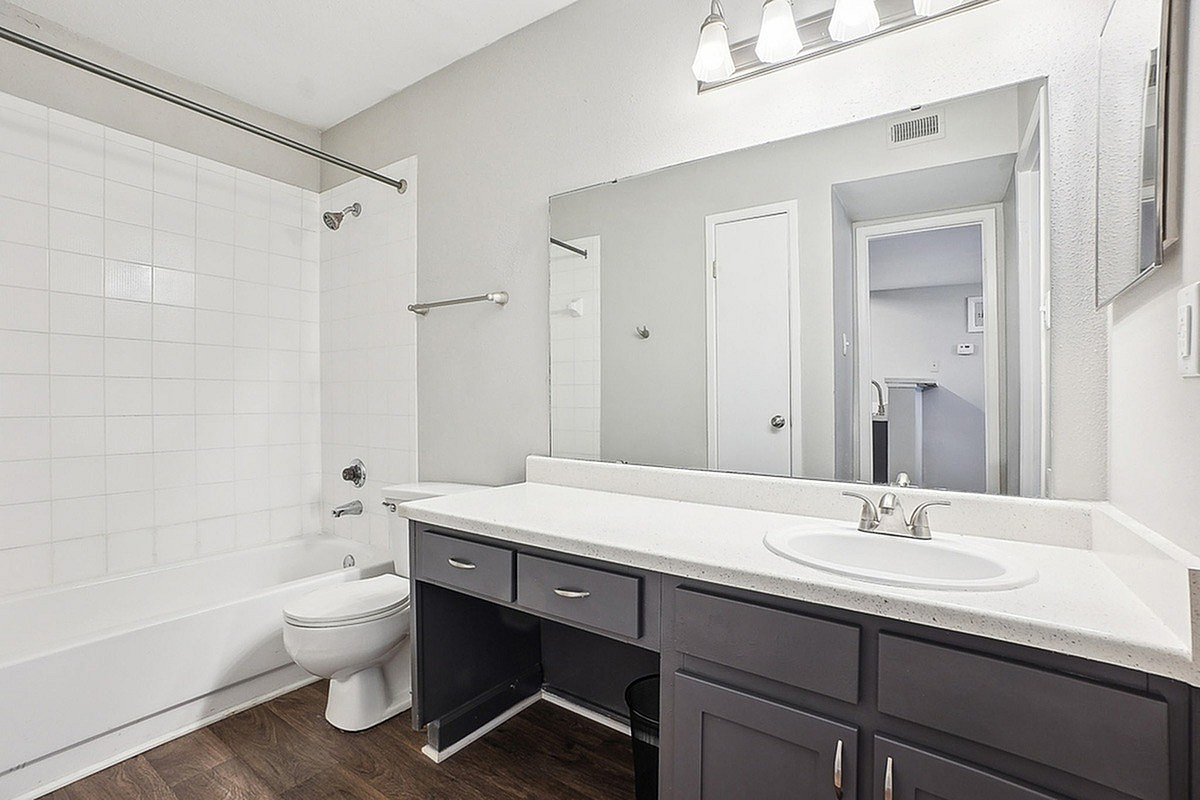 Inviting bathroom at Park at Midtown Apartments with elegant vanity, spacious mirror, and modern fixtures.