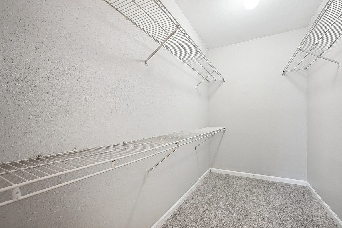 Spacious walk-in closet at Park at Midtown Apartments with ample shelving, perfect for organized storage in a modern apartment.