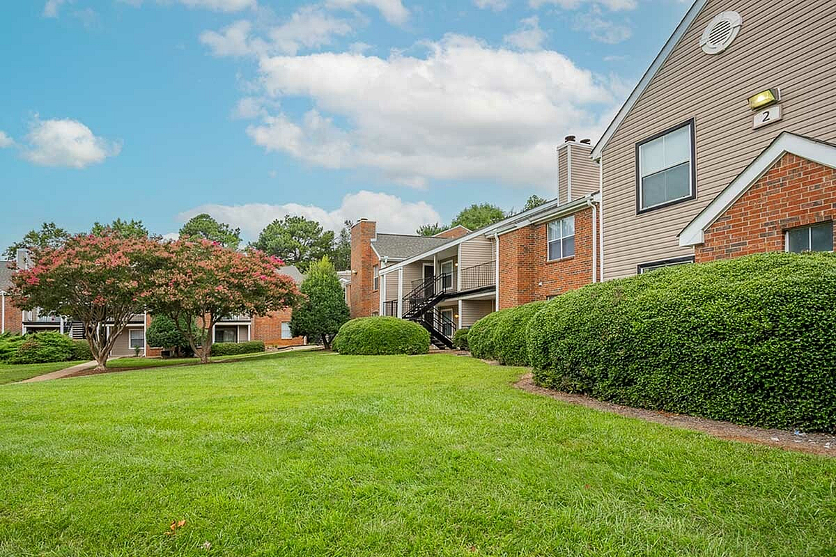 Charming apartment complex, Park at Midtown Apartments, surrounded by lush greenery and vibrant landscaping with spacious outdoor areas.