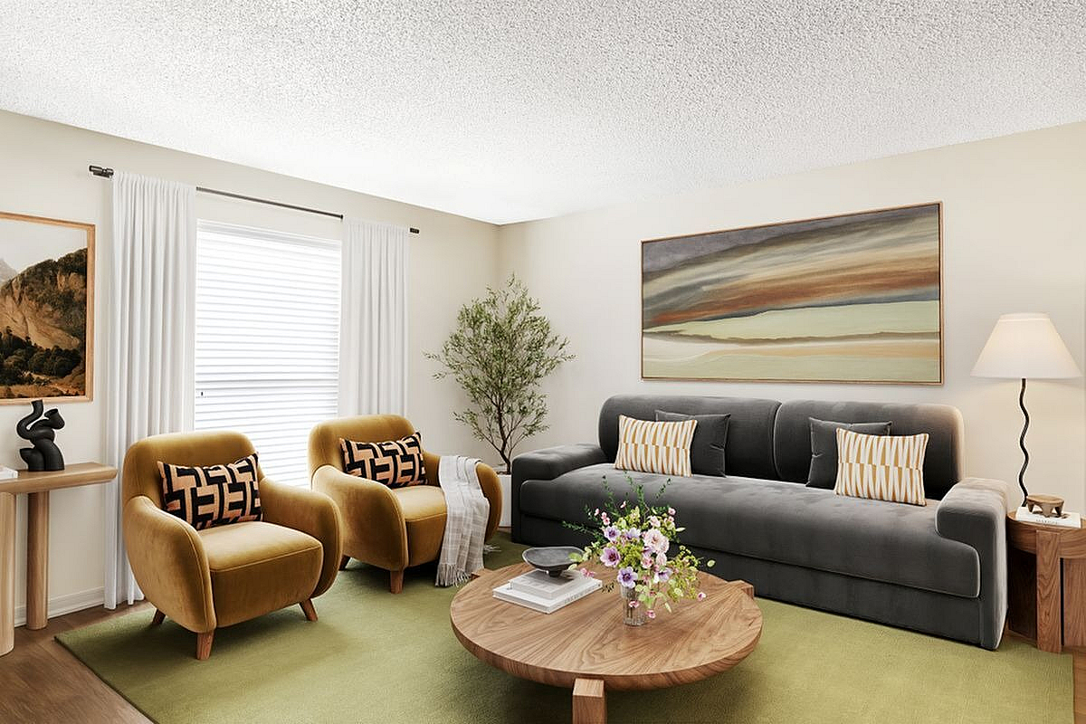 Chic living room with cozy velvet chairs, a plush sofa, and elegant decor creating a warm and inviting atmosphere at Antero Apartments in Colorado Springs.
