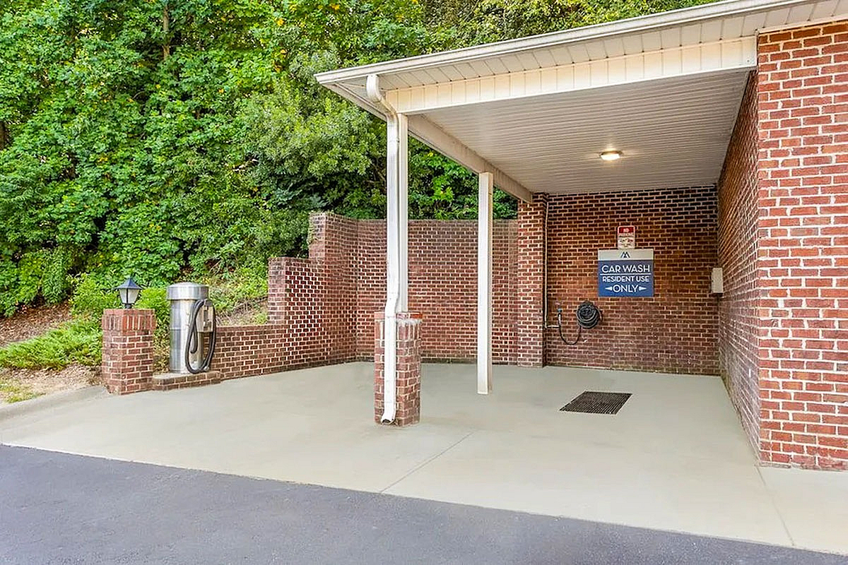 Inviting resident-only car wash area with brick walls and lush greenery, enhancing convenience and community amenities at Morgan Ridge Apartments.