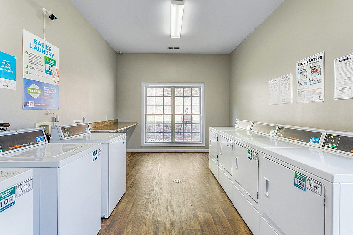 Bright and modern laundry room at Morgan Ridge Apartments with multiple washers and dryers, featuring large windows and a clean, inviting design.