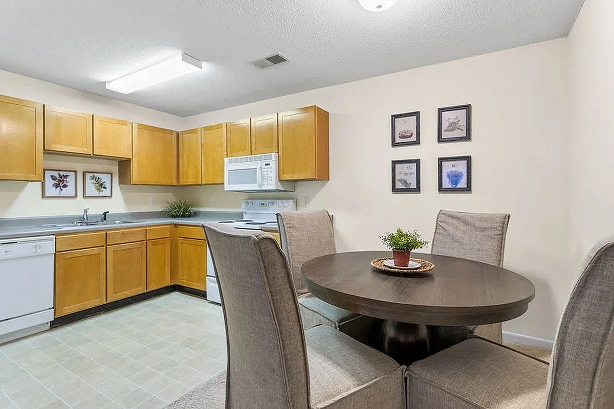 Charming kitchen and dining area at Morgan Ridge Apartments with modern appliances, cozy round dining table, and elegant wall decor.