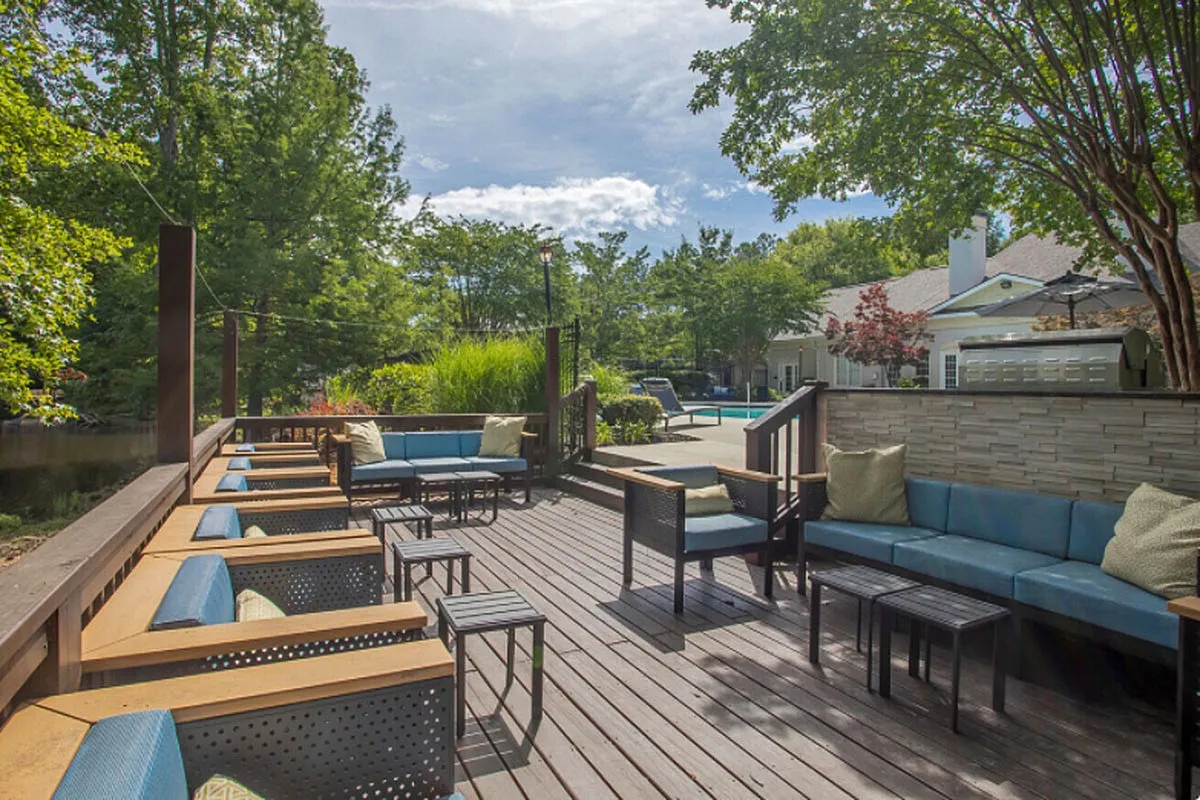 Charming outdoor deck at Lake St James Apartments with stylish seating, nestled in lush greenery, offering a serene retreat and perfect spot for relaxation.