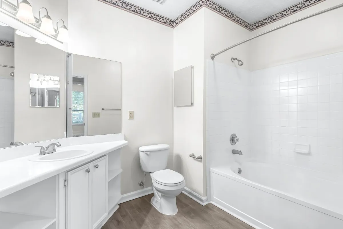 Bright, elegant bathroom with modern fixtures, white cabinetry, and a spacious bathtub, offering a serene and inviting atmosphere 2 Bedroom Apartment Bathroom at Lake St James Apartments in Conyers GA