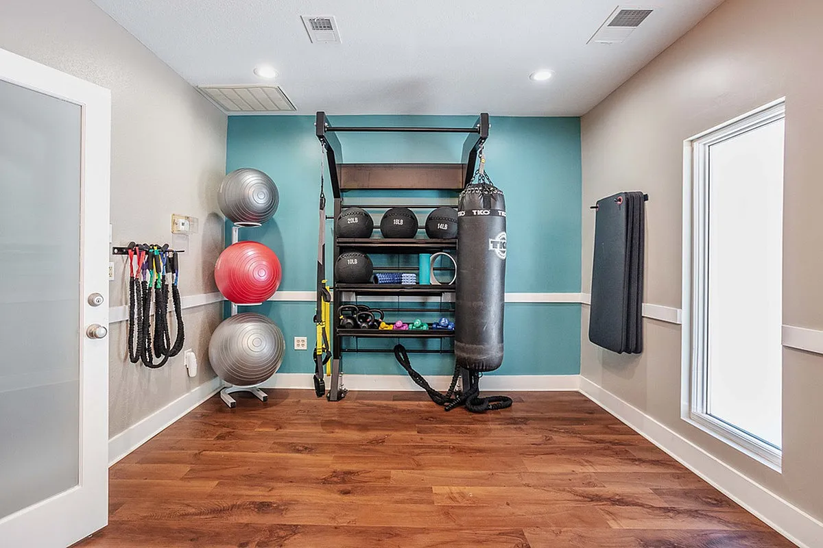 Inviting gym with polished wood floors, punching bag, stability balls, and various fitness equipment neatly arranged for a perfect workout at Timber Hollow Apartments.