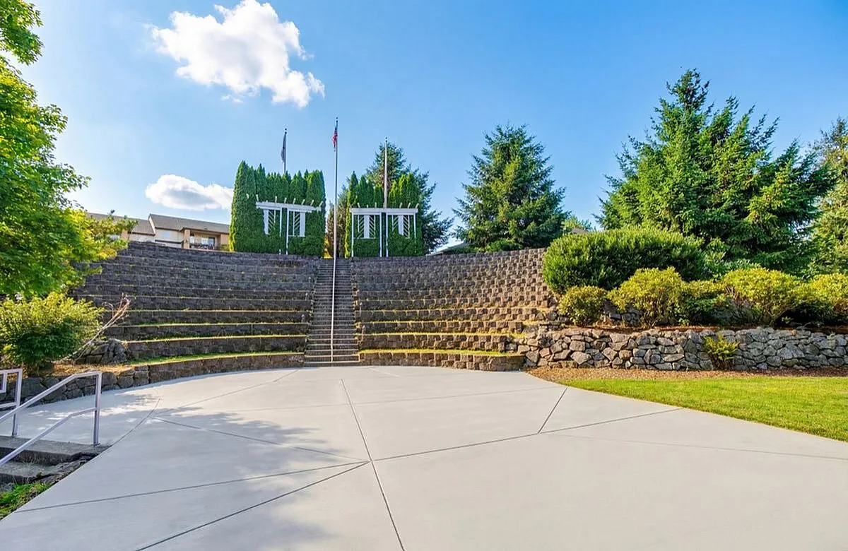 Charming outdoor amphitheater with lush greenery and tiered stone seating, perfect for open-air events and serene gatherings at Scott Mountain Apartments in Portland OR
