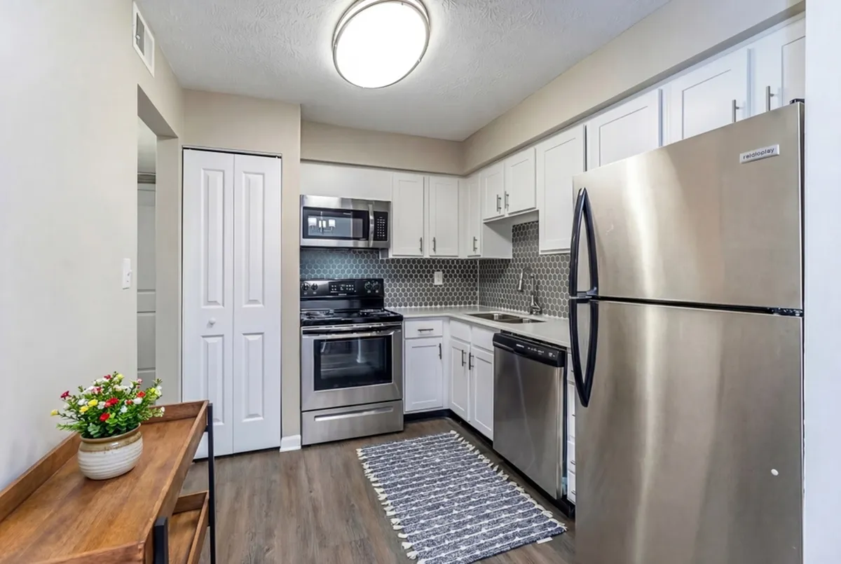 Modern kitchen with stainless steel appliances, sleek cabinetry, and stylish backsplash, featuring a cozy ambiance.
