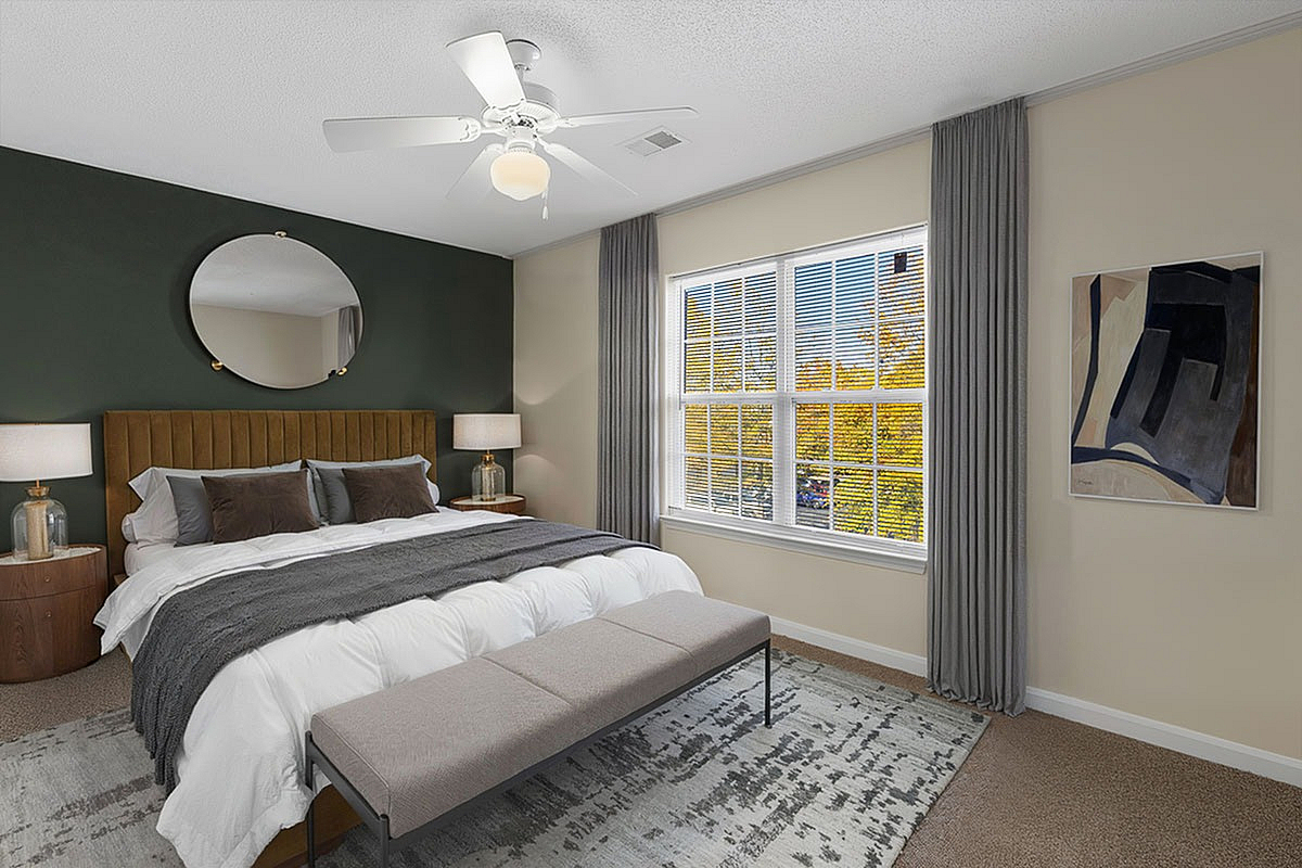 Elegant bedroom featuring a plush king-sized bed with modern decor, large windows offering abundant natural light, and stylish artwork.
