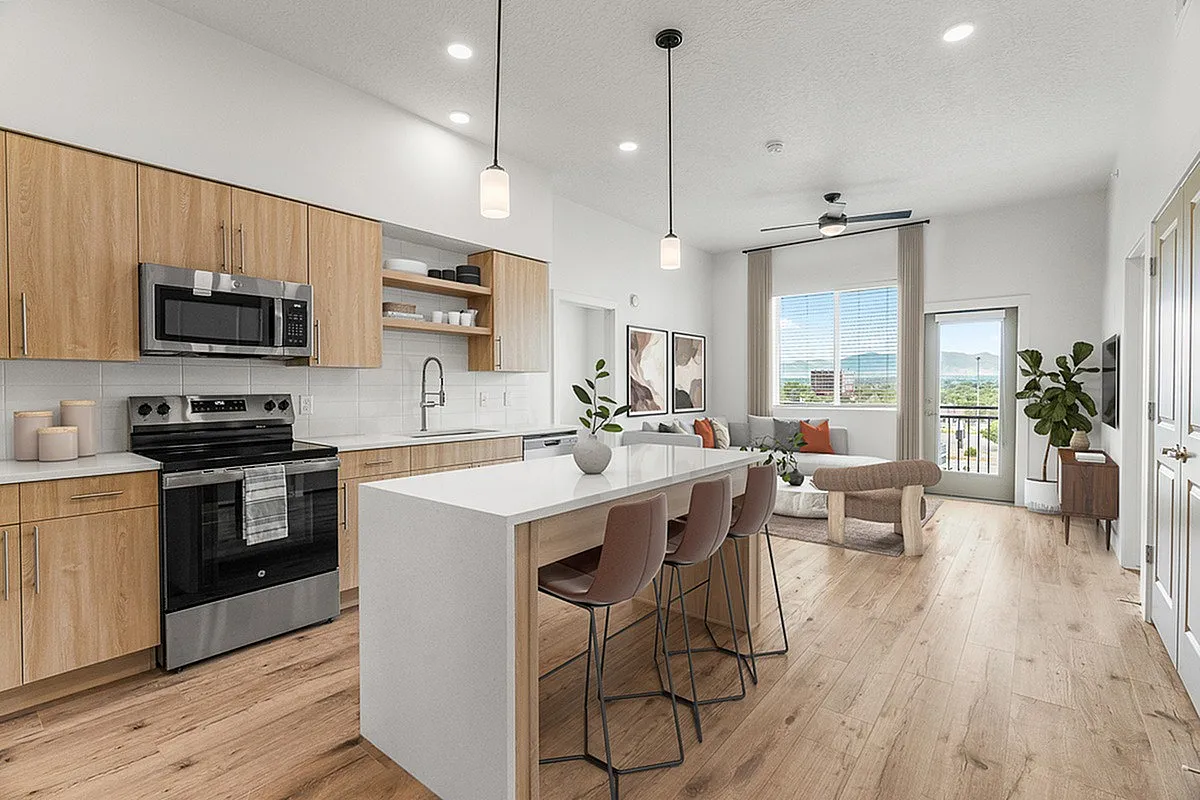 Sleek modern kitchen and living area with open-concept layout, featuring natural wood finishes, stylish lighting, and large windows offering stunning views.
