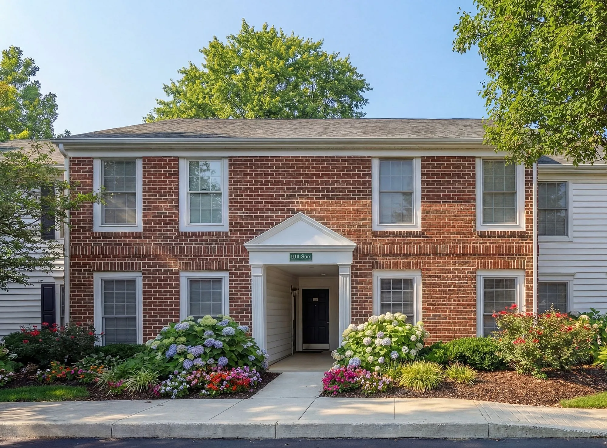 Charming brick apartment building with lush landscaping and a welcoming entrance in a serene neighborhood at Alkire Glen Apartments in Columbus, OH.