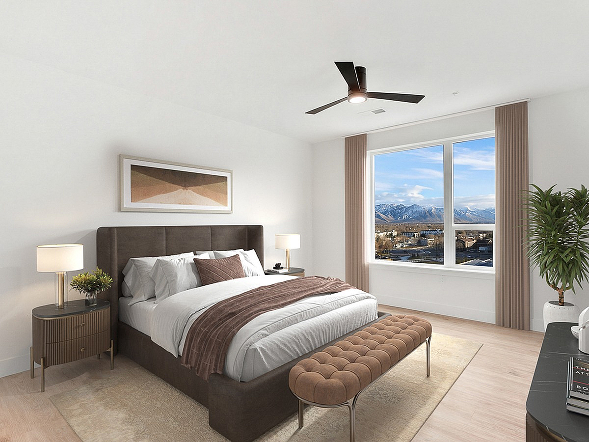Modern bedroom at The Westerly Apartments with a cozy bed, stylish decor, and a mountain view through a large window.