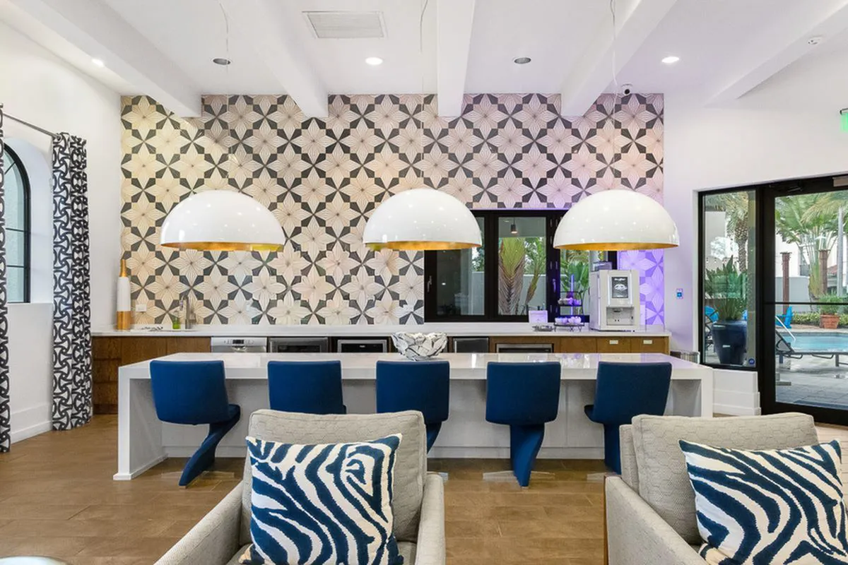 View of Cottonwood Lighthouse Point Clubroom Showing Large Flat Screen TVs, Lounge-Style Seating, Large Pendant Lighting, Quartz Waterfall Countertops, and High Ceilings and Plank-Style Flooring