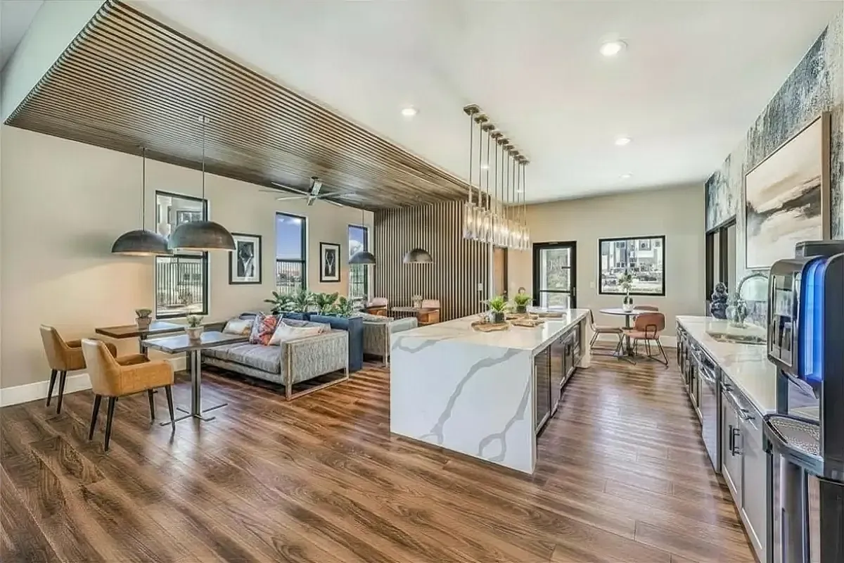 Luxurious open-plan clubroom at Summit on Boulder Apartments featuring stylish kitchen island, elegant dining area, and cozy seating with modern decor.