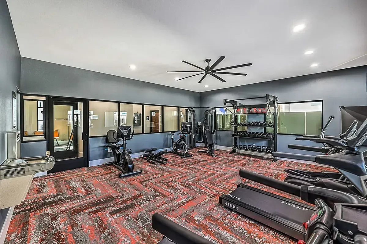 Modern fitness center at Summit on Boulder Apartments with state-of-the-art gym equipment, vibrant flooring, and spacious layout for an energizing workout experience.