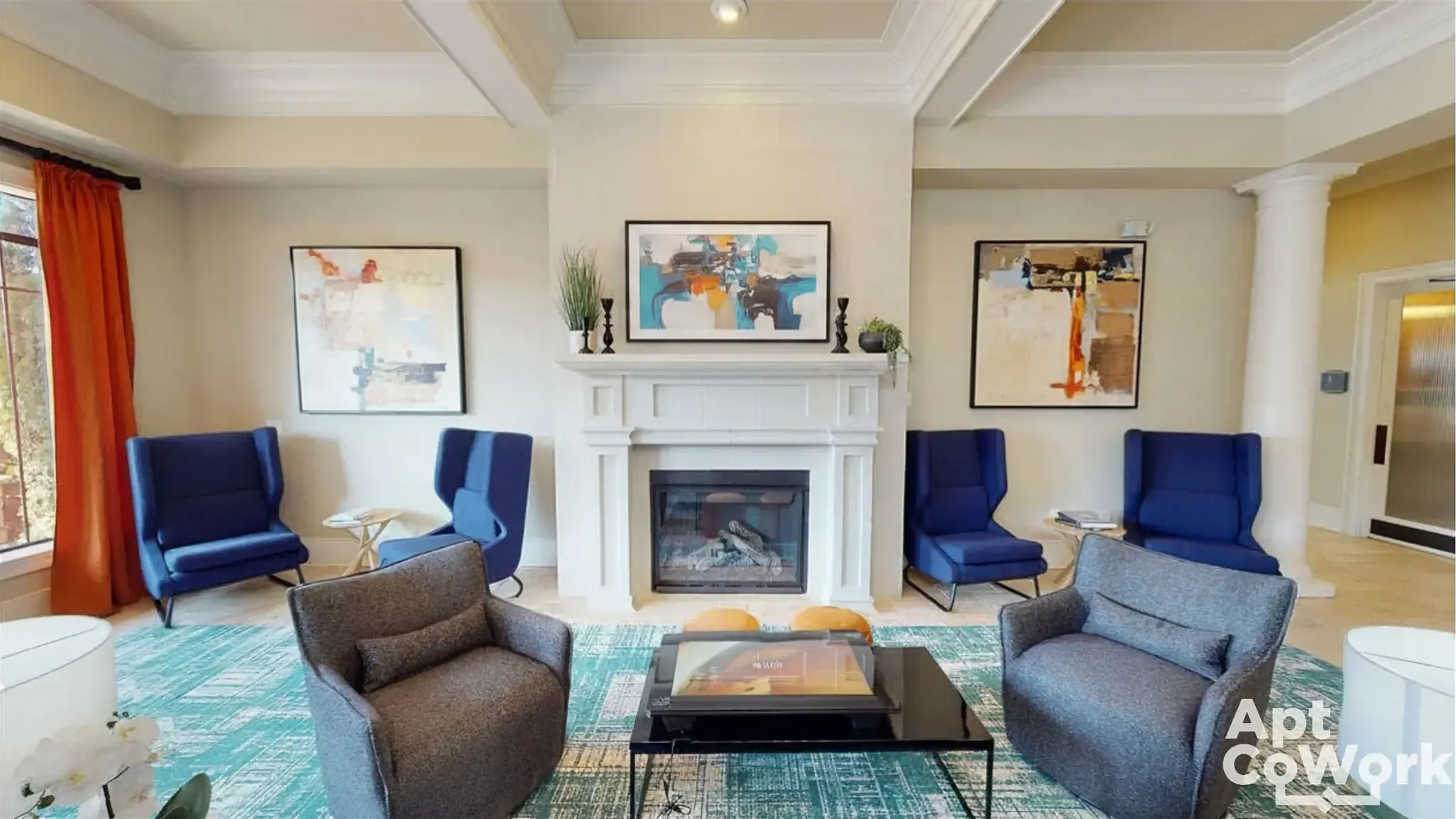 Elegant seating area at Heights at Meridian Apartments featuring a cozy fireplace, modern art, and plush seating with vibrant blue accents.