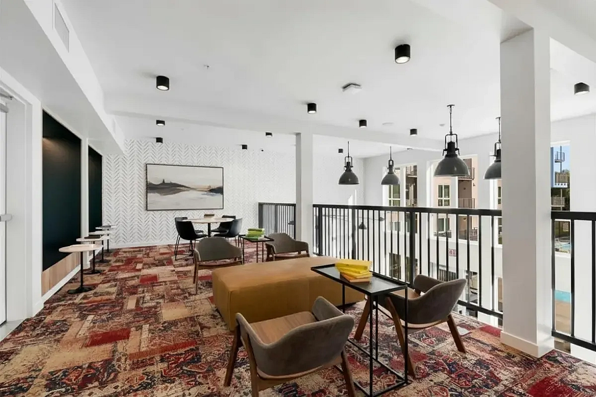 Elegant lounge area featuring modern furniture, patterned carpet, and stylish lighting fixtures at 805 Riverfront Apartments in Sacramento