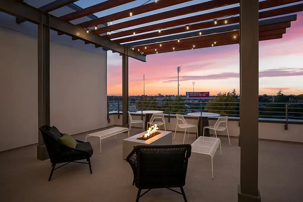 Trendy rooftop lounge featuring stylish seating, a modern fire pit, and panoramic sunset views at 805 Riverfront in Sacramento