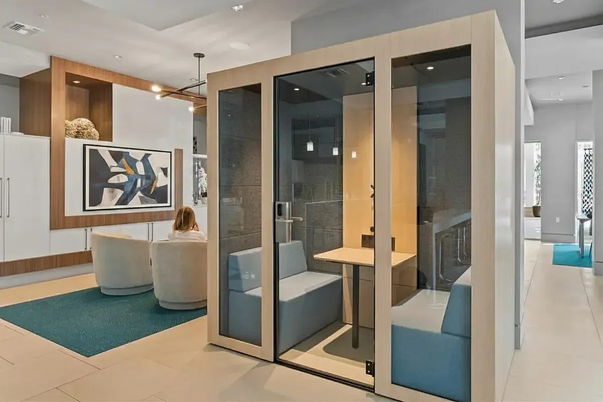 Modern lounge area with sleek seating, flat screen TV, and private pod seating.