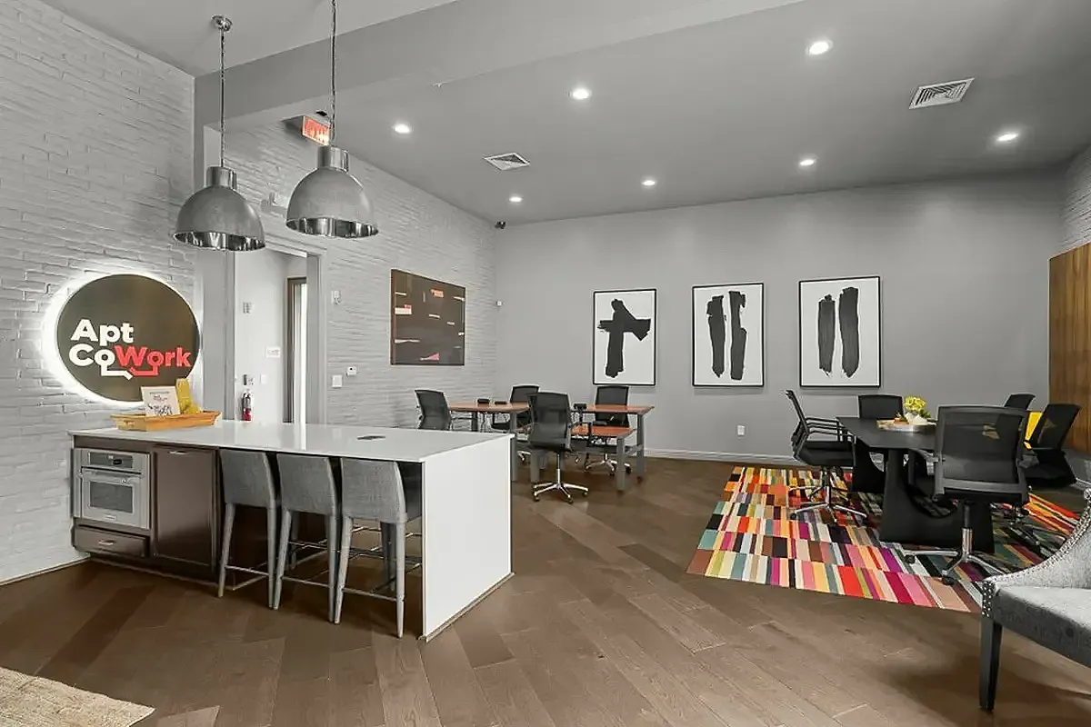 Modern coworking space with stylish furniture, vibrant decor, and sleek kitchenette area at Apt CoWork in Charlotte, NC