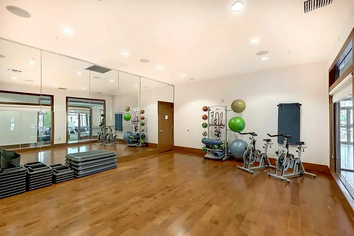 View of Yoga Space, Showing Stationary Bicycles, Exercise Balls, Medicine Balls, and Yoga Mats at The Marq Highland Park Apartments in Westchase