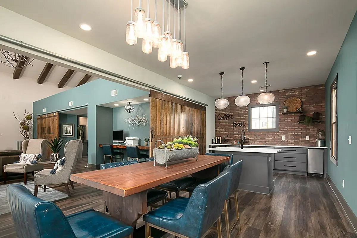 Charming clubroom at The Mill at Georgetown Apartments featuring rustic wood accents, stylish pendant lights, and a cozy coffee bar with brick detailing.