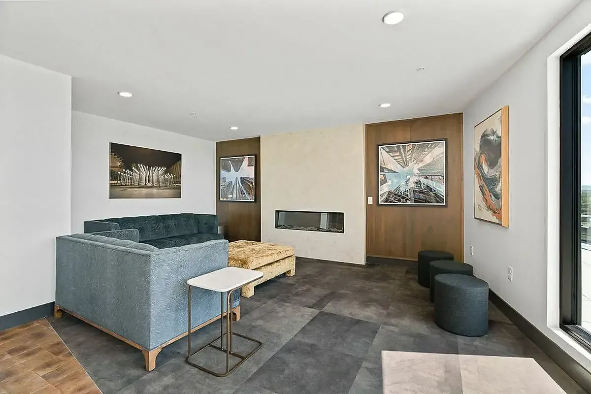 Clubroom area with stylish decor featuring a plush sectional sofa, sleek wall-mounted TV, and contemporary artwork, perfect for relaxation and entertainment at The Richmond Apartments in SLC Utah